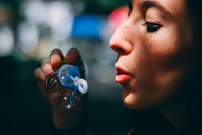Close-up of young woman blowing bubble