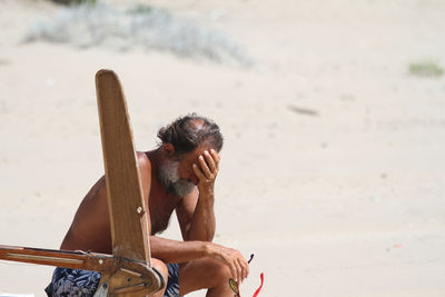 Full length of shirtless man at beach