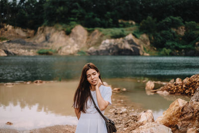 Portrait of woman standing against water