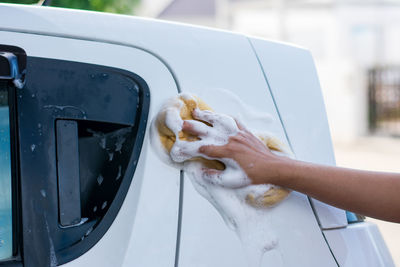 Midsection of woman holding ice cream in car