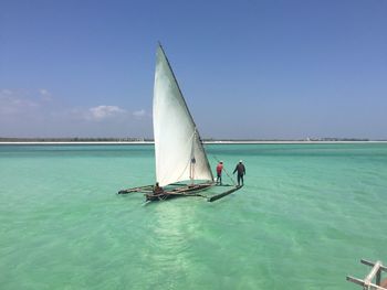 Outrigger sailing in sea against sky