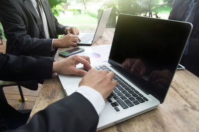 Midsection of businessmen working at desk in office