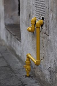 Close-up of safety yellow gas piping on sidewalk.