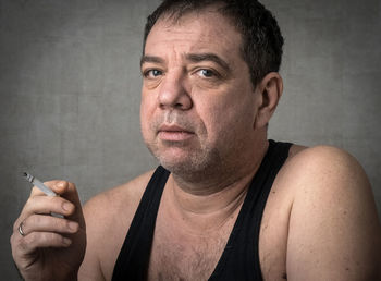 Man smoking against wall