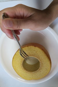 Cropped image of person pouring baumkuchen