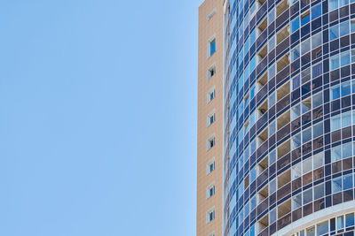 Low angle view of modern building against clear blue sky