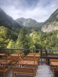 Empty chairs and tables against sky