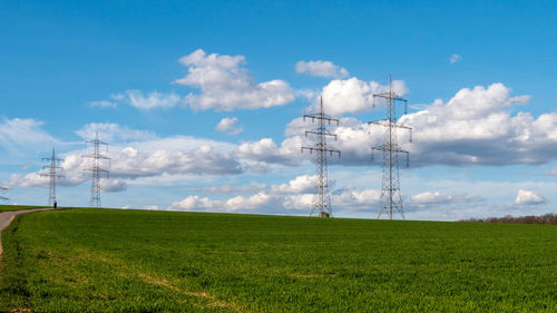 Electricity pylon on field against sky