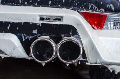 Close-up of exhaust pipes of wet car