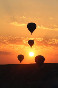 Silhouette hot air balloon against sky during sunset