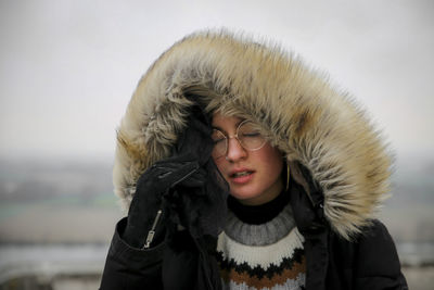 Portrait of woman in snow against sky during winter