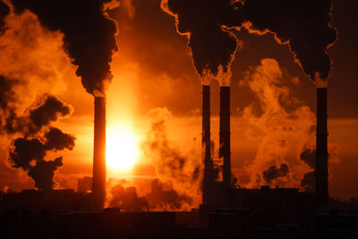 Air pollution and global warming. smoking chimneys of thermal power plant at sunset in winter city