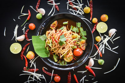 Directly above shot of fruits in plate against black background