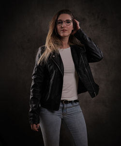 Young woman standing against black background