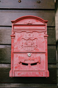 Close-up of red mailbox on wall