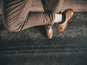 Low section of woman wearing shoes on floor