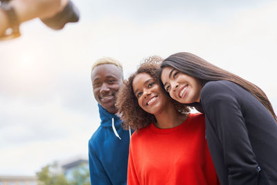 Portrait of a smiling young woman against the sky