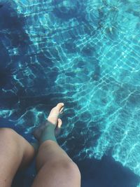 Low section of woman sitting in swimming pool