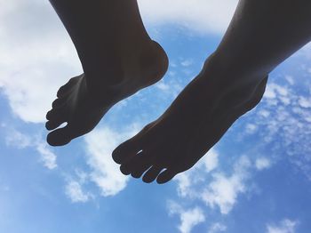Low section of woman against cloudy sky