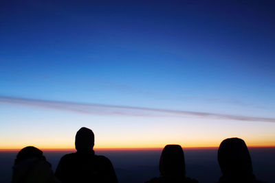 Silhouette people against clear sky during sunset