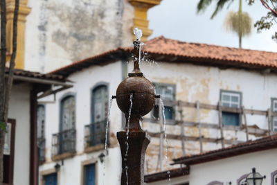 Low angle view of electric lamp hanging on building