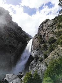 Low angle view of waterfall against sky