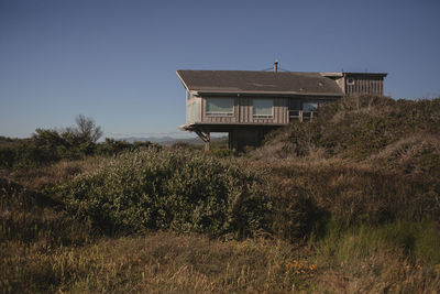 House on field against clear sky