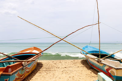 Ship moored on beach against sky