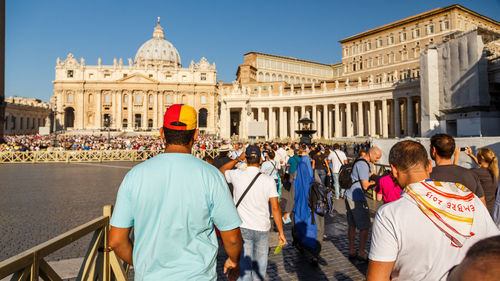 Rear view of people outside temple against sky