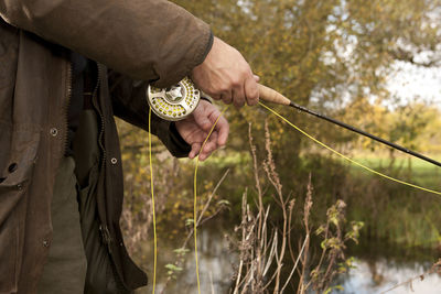 Close up of man holding fly fishing reel in the uk