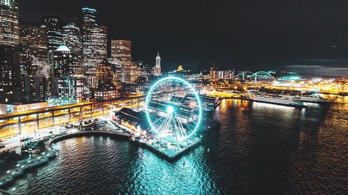 Illuminated ferris wheel in city at night