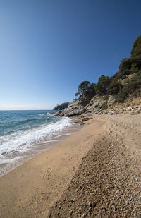 Scenic view of beach against clear blue sky