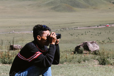 Man photographing camera on land