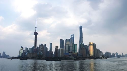 View of buildings in city against cloudy sky