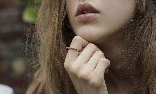 Close-up of woman with hand holding hair