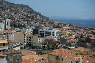 High angle view of townscape by sea against sky