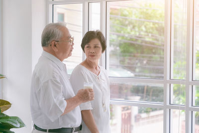 Friends standing by window