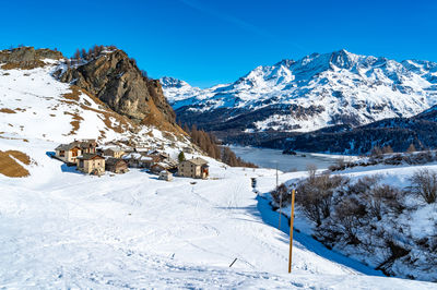 View of the village of grevasalvas, and lake sils, in engadine, switzerland, in winter.