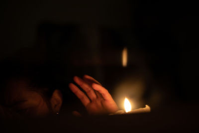 Close-up of hands burning candle