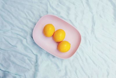 High angle view of fruits in plate on bed