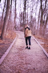 Full length rear view of man walking on footpath