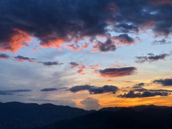 Scenic view of silhouette mountains against dramatic sky