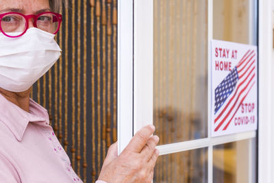 Portrait of woman holding text on window