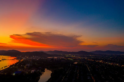 High angle view of illuminated city against sky during sunset