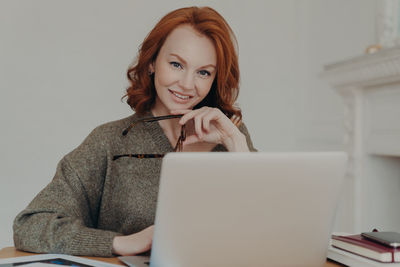 Portrait of smiling businesswoman using laptop at home