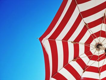 Low angle view of flag against clear blue sky