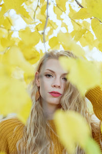 Portrait of young woman with yellow leaves