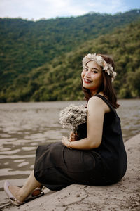 Side view of young woman sitting on beach