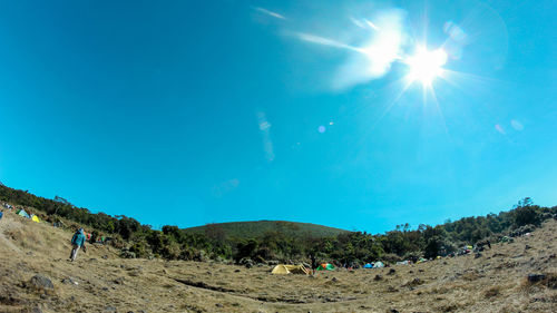 Panoramic view of people outside tent on field during sunny day