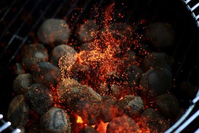 Close-up of sparks rising from barbecue grill